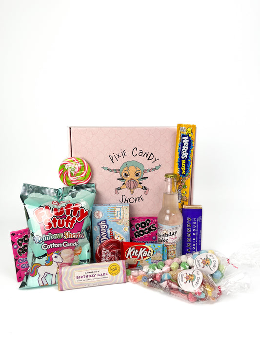 A pixie candy branded pink box with an assortment of birthday themed candy and treats displayed in front. 