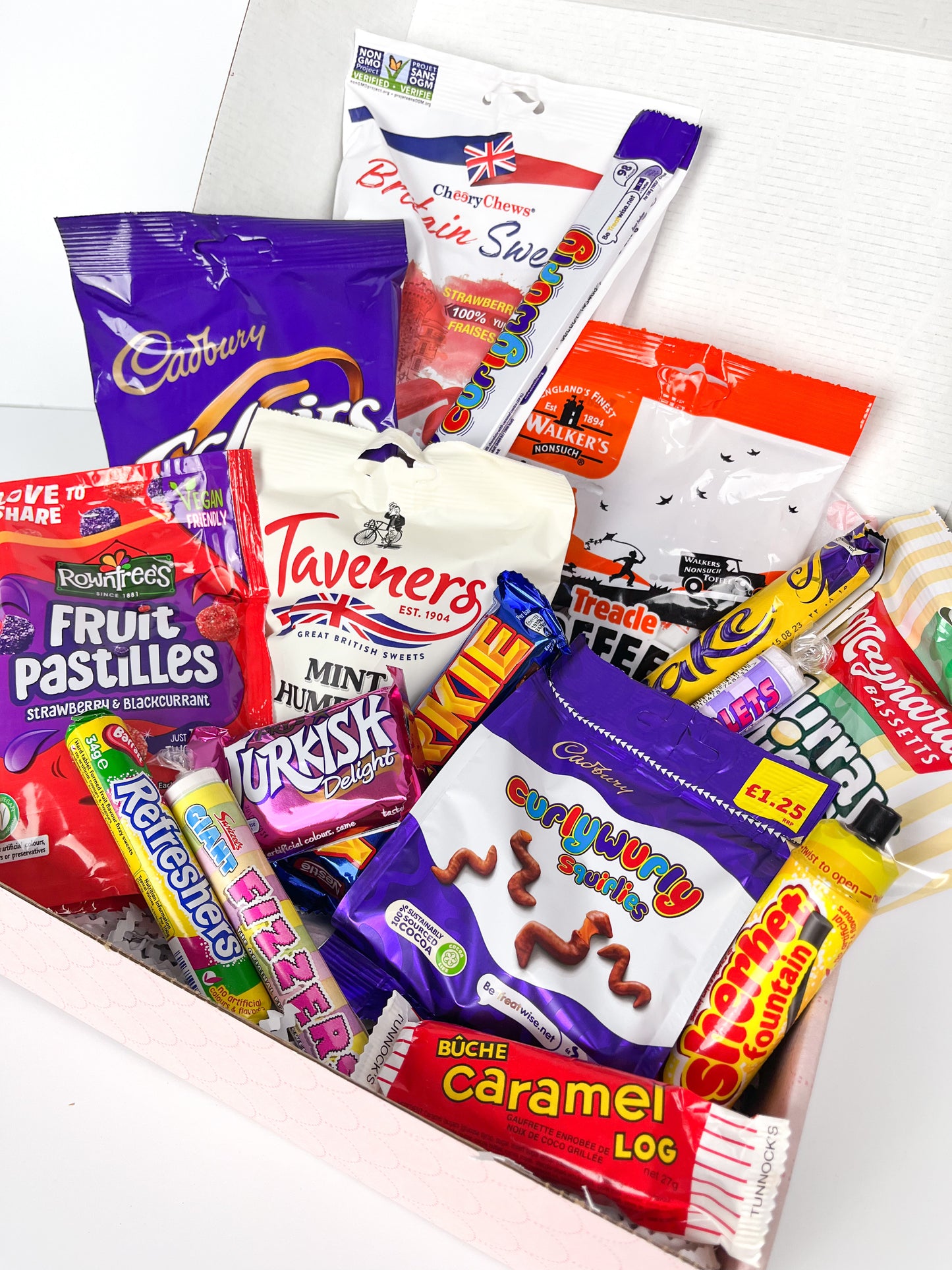 A collection of UK origin sweets displayed in an open gift box.