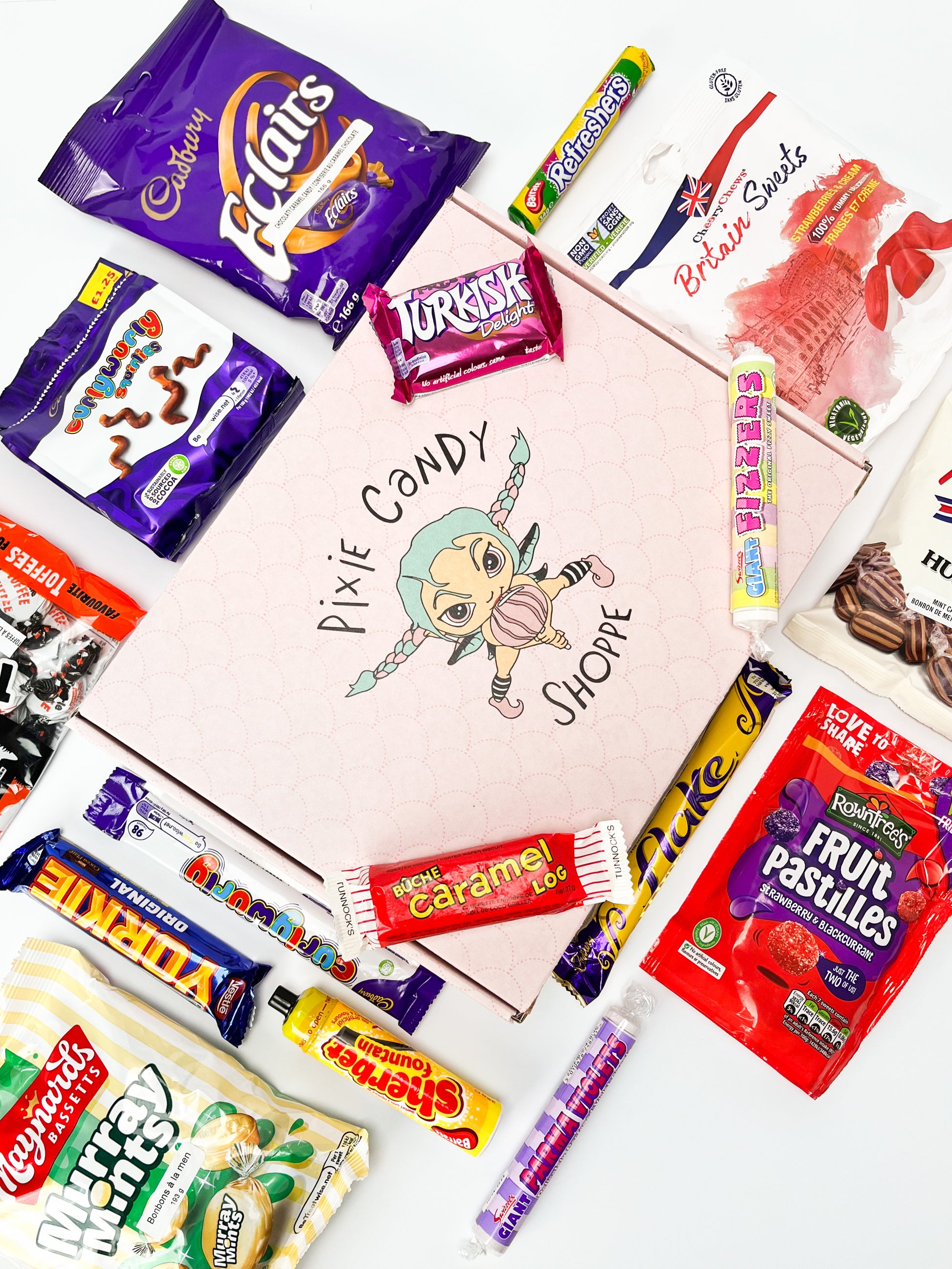 A collection of UK candy and chocolates displayed around and on a pixie candy branded gift box viewed from a bird's eye view angle.